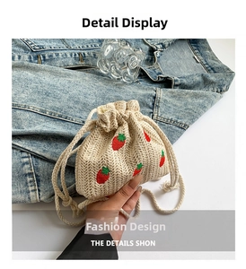 Detail view of cream crochet bucket bag featuring red strawberry embroidery and drawstring