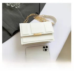 Quilted white crossbody bag size comparison with a smartphone and golden chain detail