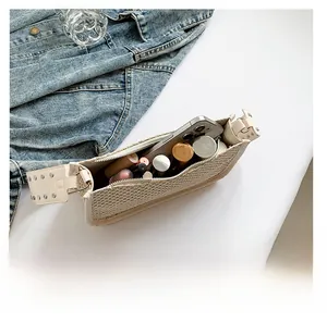 Interior view showing the storage capacity of a beige straw shoulder bag with cosmetics