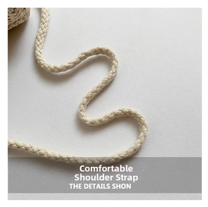 Close-up of the comfortable braided cream shoulder strap on the woven bucket bag
