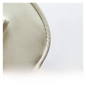 Vue macro détaillée de la texture du cuir blanc crème avec grain de litchi sur le sac à main