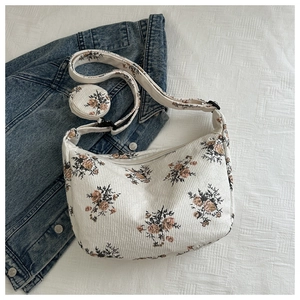 Retro floral corduroy tote bag with small coin purse displayed with denim jacket