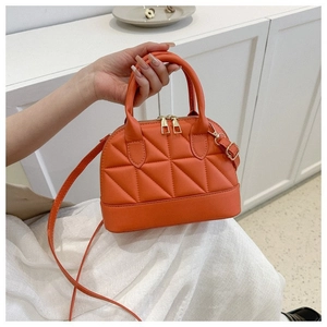 Orange quilted shell handbag with gold hardware and removable shoulder strap shown on model