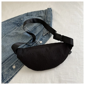 Detail of black crescent moon waist bag with bubble textured fabric and nylon strap