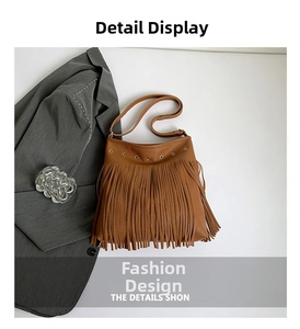 Detailed close-up of brown textured leather tote bag with fringe and metal eyelets