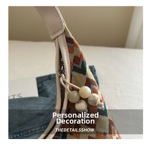 Detail of geometric jacquard fabric bag with leather trim and marbled bead zipper pulls