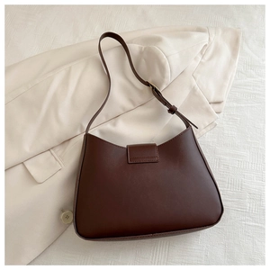Detail of a dark brown matte leather underarm bag with rectangle buckle and adjustable strap