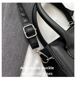 Détail du sac à main en cuir noir avec boucle argentée réglable et fermoir mousqueton
