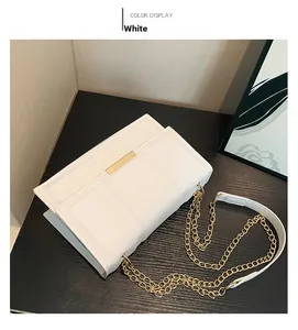 Detailed shot of white faux leather bag with golden metal buckle and chain strap
