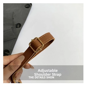 Detail view of adjustable dark brown pebble grain leather shoulder strap with gold buckle