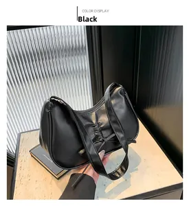 Détail du sac sous le bras en similicuir plissé noir avec nœud décoratif et fermeture éclair
