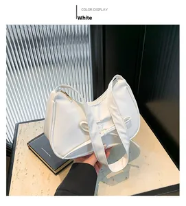 Détail d'un sac à main blanc en forme de croissant avec nœud décoratif et fermeture éclair