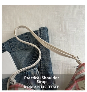 Detail of pink plaid tote bag showing the faux leather strap and silver metal buckle