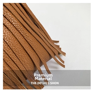 Close-up of brown litchi pattern leather and long fringe tassels on a stylish hobo bag