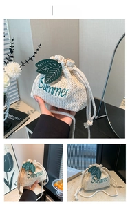 Detail of straw bucket bag featuring Summer embroidery and 3D leaf ornaments on woven texture