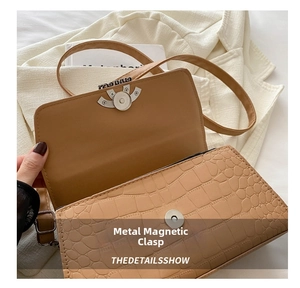 Detail of the camel crocodile embossed leather bag with magnetic snap closure