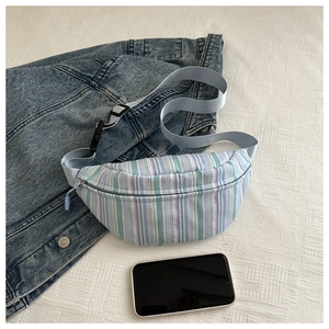 Gros plan d'un sac banane rayé avec bandoulière réglable et boucle en plastique robuste