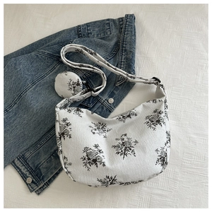 Detail of white corduroy hobo bag with vintage floral print and small round coin purse charm