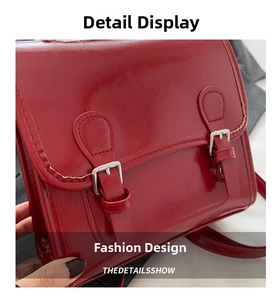 Detail shot of the glossy red patent leather surface and double buckle closure