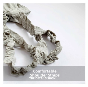 Detailed close-up of light grey-green ruffled shoulder strap with visible stitching