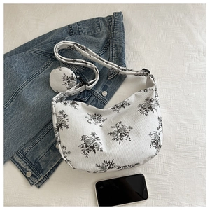 Close-up of floral nylon shoulder bag with matching coin purse and wide strap detail