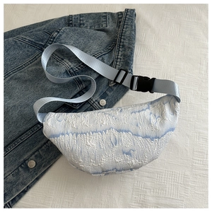 Close-up of white and light blue jacquard chest bag with adjustable nylon strap and buckle
