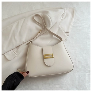 Detail of a creamy white half-moon shoulder bag with a sleek gold rectangular metal buckle