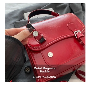 Detail of red PU leather mini backpack with magnetic metal buckle and strap closure