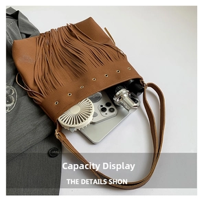 Detailed view of large capacity brown tassel tote bag with items inside the main pocket