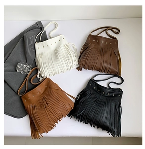 Detailed view of four colorful fringe shoulder bags with litchi grain leather and metal eyelets