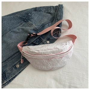 Dettaglio del marsupio in tessuto a bolle rosa e bianco su sfondo di giacca di jeans