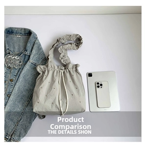 Grey nylon bucket bag with studded detail showing size compared to a tablet