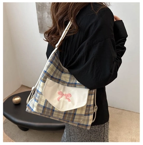 Detail of plaid tote bag with pink bow embroidery and adjustable leather strap