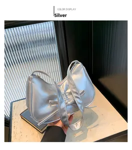Détail du sac à main argenté avec nœud papillon en cuir synthétique effet métallisé