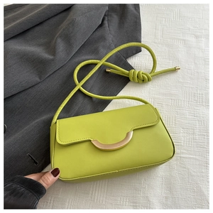 Détail du sac à bandoulière vert vif avec fermoir doré et bandoulière à nœuds