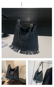 Close-up of black hobo bag with fringe details and textured pebble leather and gold buckles