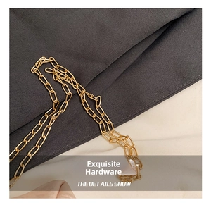Κοντινό πλάνο χρυσής μεταλλικής αλυσίδας με γυαλισμένους κρίκους για πολυτελή τσάντα