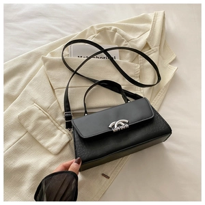Detail of black crocodile embossed crossbody bag with decorative silver buckle hardware