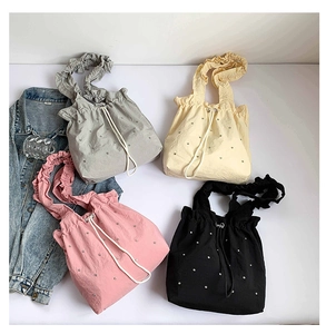 Detailed view of rhinestone drawstring tote bags in four colors with ruffled straps