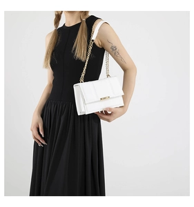 Detail of white quilted leather crossbody bag with gold chain and metal lock on model