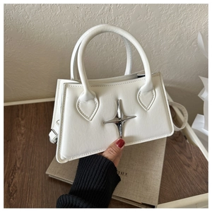 Détail du sac à main en cuir blanc cassé avec ornement étoile argentée et poignées plates
