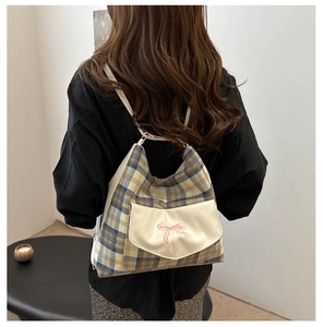 Detail of plaid canvas backpack with pink bow embroidery and adjustable straps