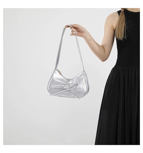 Détail du sac demi-lune argenté métallisé avec nœud et texture en cuir PU lisse