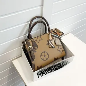 Detail of vintage floral pattern on brown leather bag with silk scarf and gold hardware