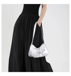 Détail du sac de style ballet argenté avec un nœud 3D central et fermeture éclair
