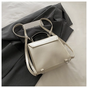 Detail of pearlescent white PU leather backpack with metallic ring and trapezoidal flap