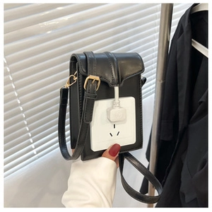Detail of trendy black velvet crossbody bag featuring unique socket design and gold hardware