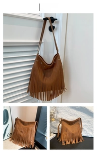 Detail of brown litchi leather tote featuring metal eyelets and bohemian fringe tassels