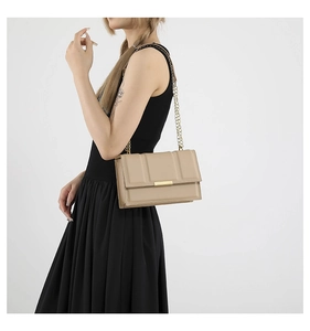 Close-up of a beige quilted chain shoulder bag featuring gold-tone hardware and buckle