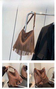 Detail of coffee brown pebble leather hobo bag with long bohemian tassels and gold eyelets